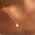 Collier en perles dorées avec pendentif en opale