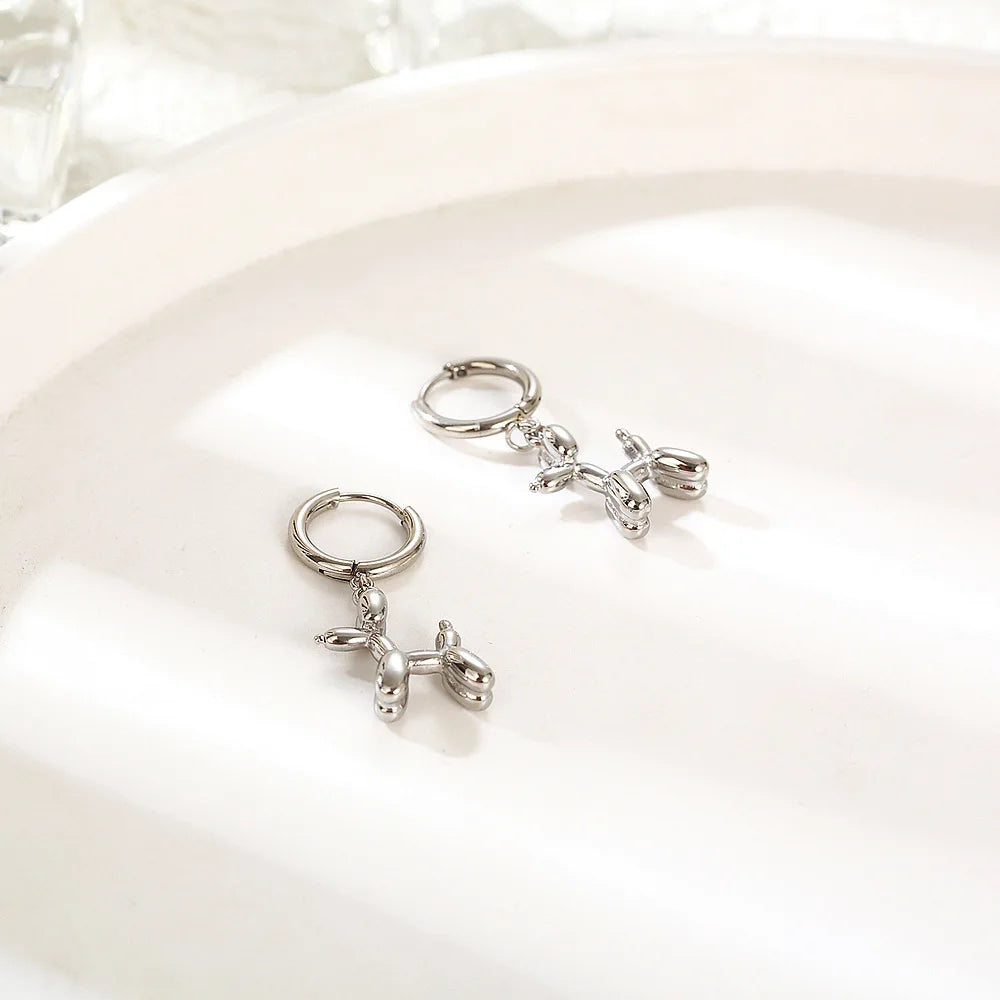 Boucles d'oreilles huggie en or mini avec un charm en forme de chien ballon